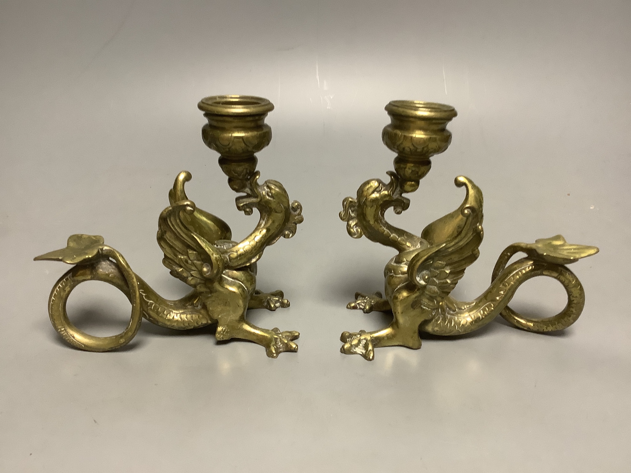 A pair of Benson-style bronze candlesticks, 32cm, and a pair of 'griffin' candle holders